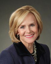 Professional portrait of a smiling woman with blonde hair.
