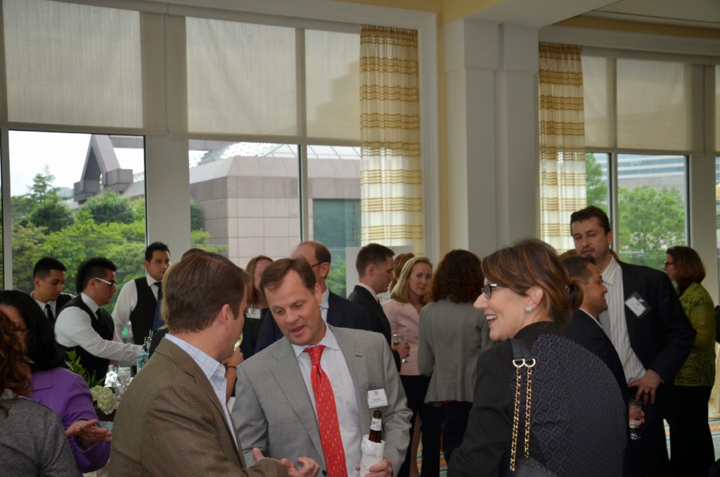 People networking and conversing at a professional indoor event.