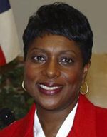 Portrait of a smiling woman in a red blazer.
