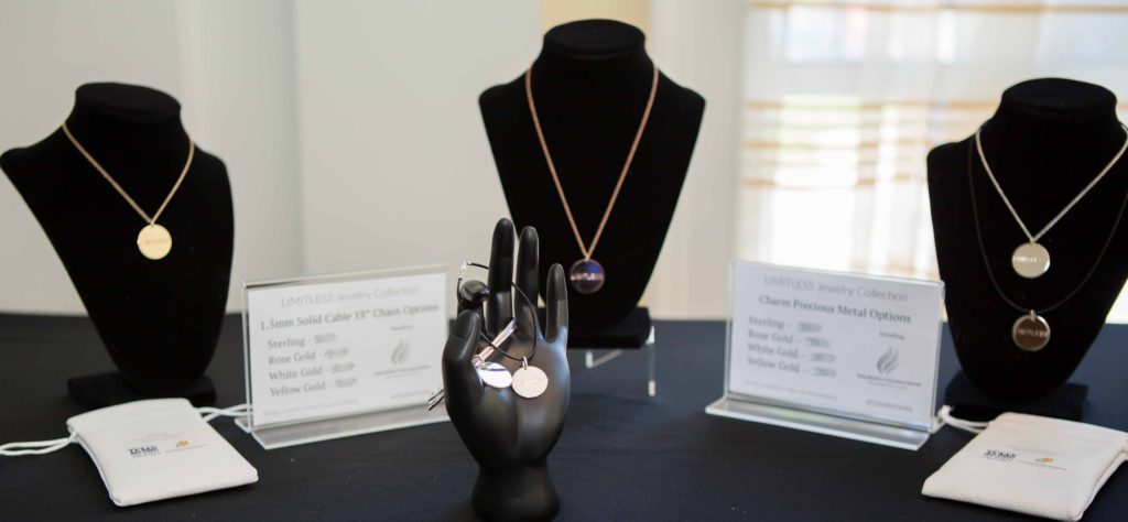 Elegant jewelry displayed on a black mannequin and hand stand.