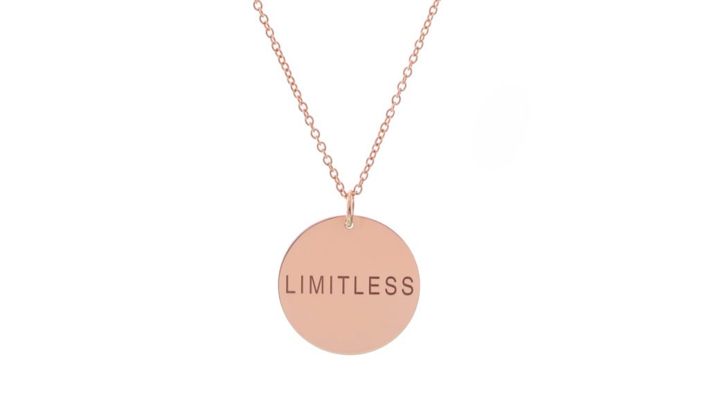 Rose gold necklace with a pendant engraved 'LIMITLESS'.