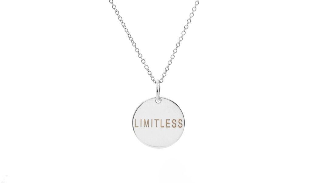 Silver necklace with a round pendant engraved 'LIMITLESS'.