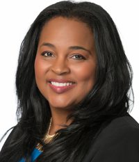 Professional headshot of a smiling woman with long black hair.