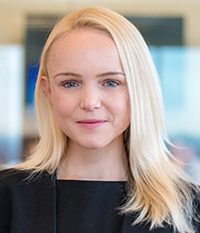 Professional portrait of a confident blonde woman in a business setting.