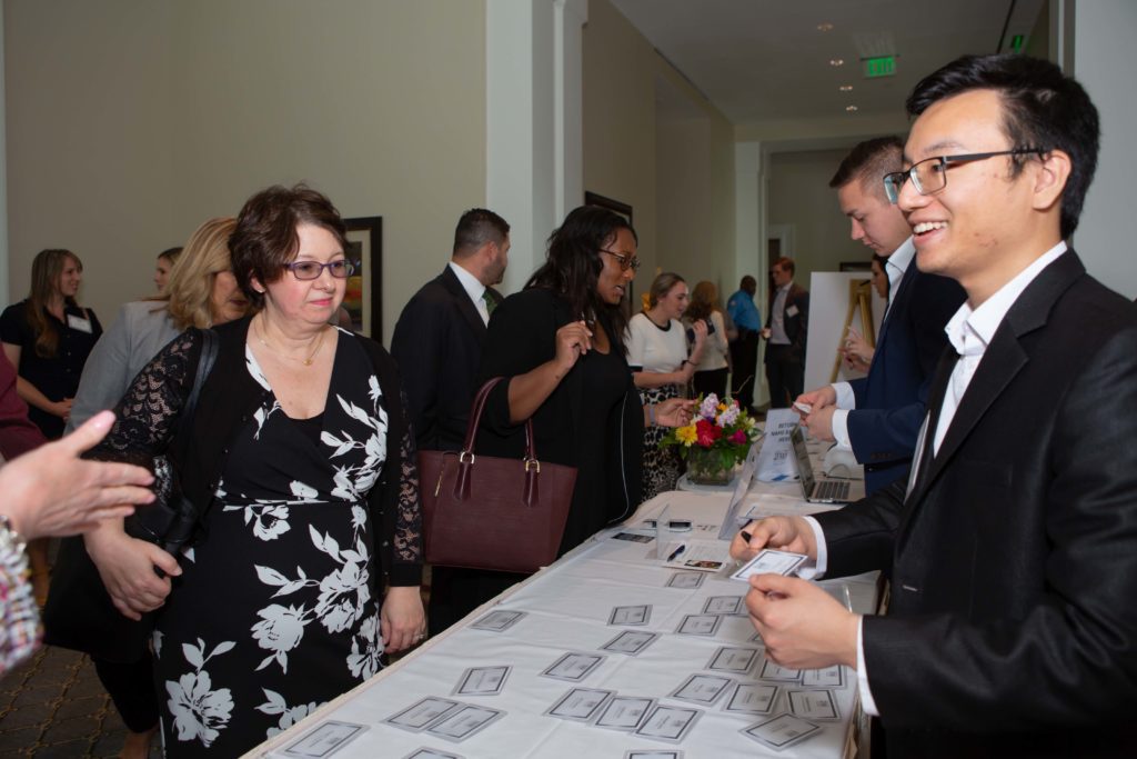 People engaging at a registration table during an event.