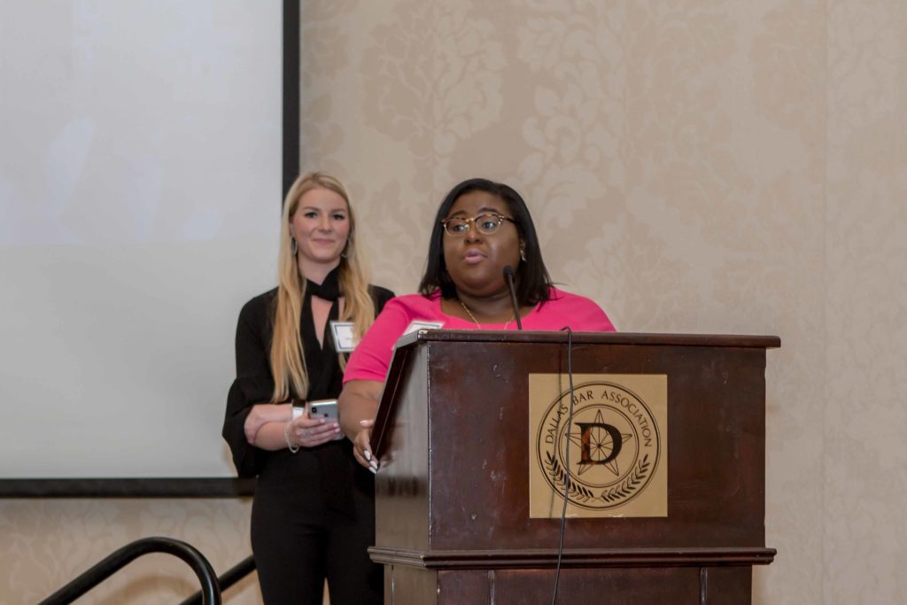 Two women speaking at a podium during an event.