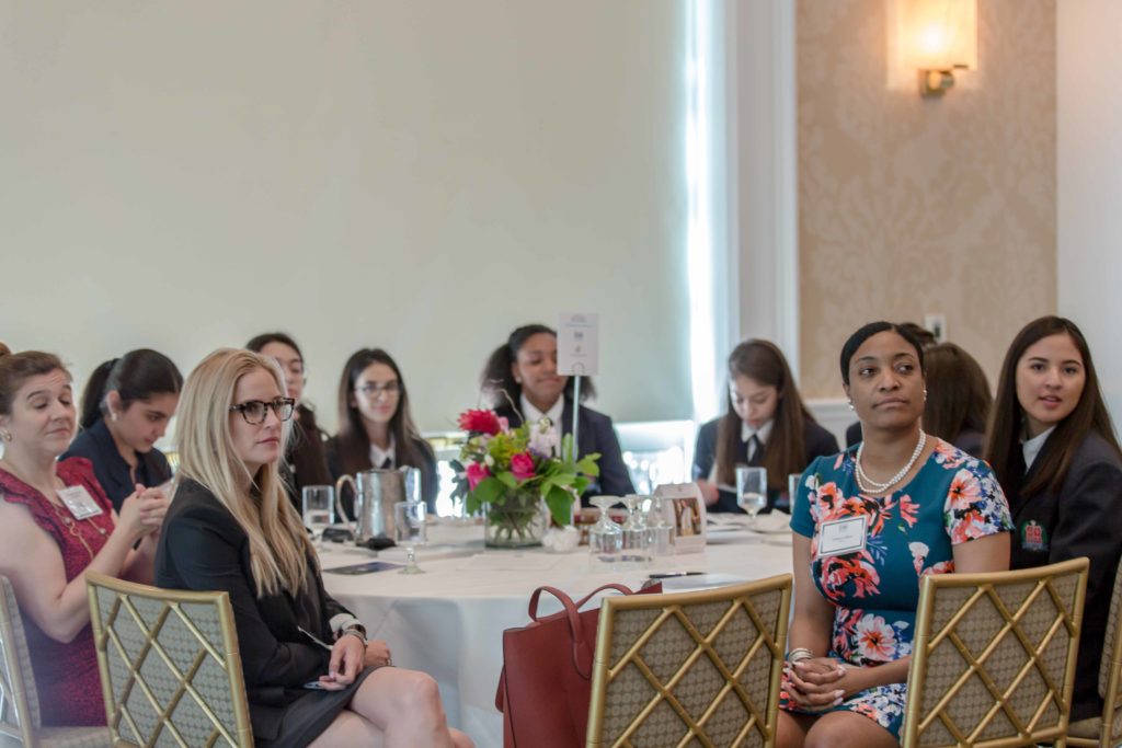 People attentively listening during a formal indoor meeting or seminar.