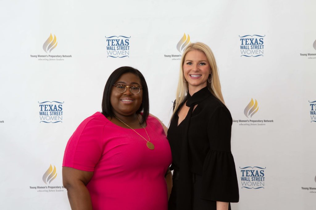 Two women smiling in front of a Texas Association backdrop.