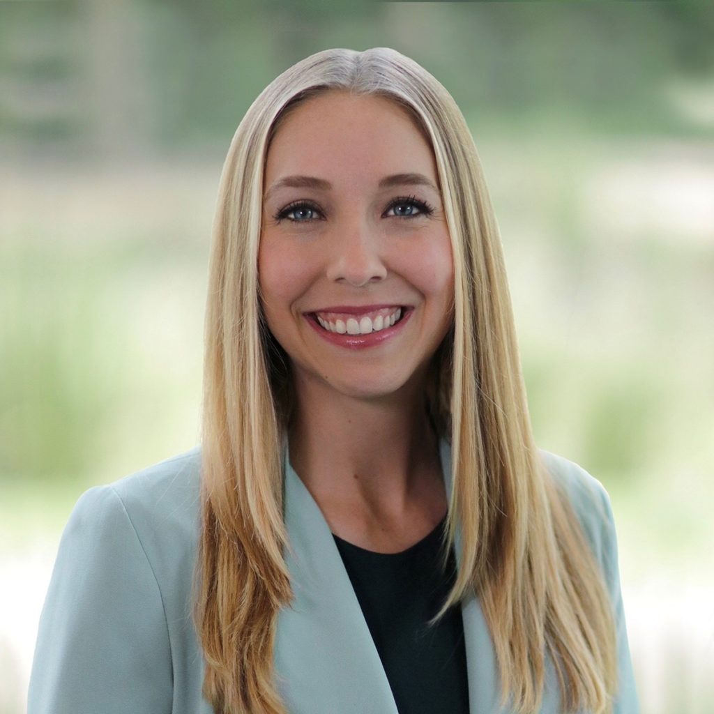 Smiling woman with long blonde hair in a light blue blazer.