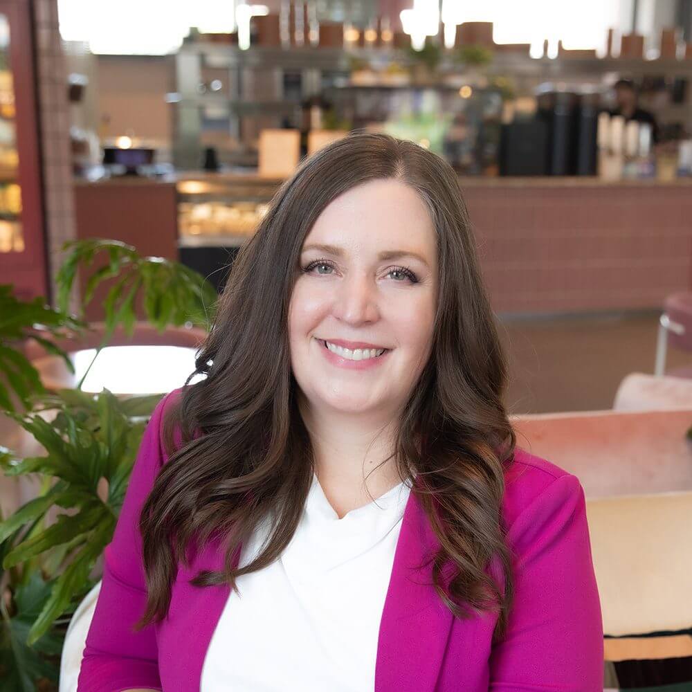 Woman smiling in a cafe setting.