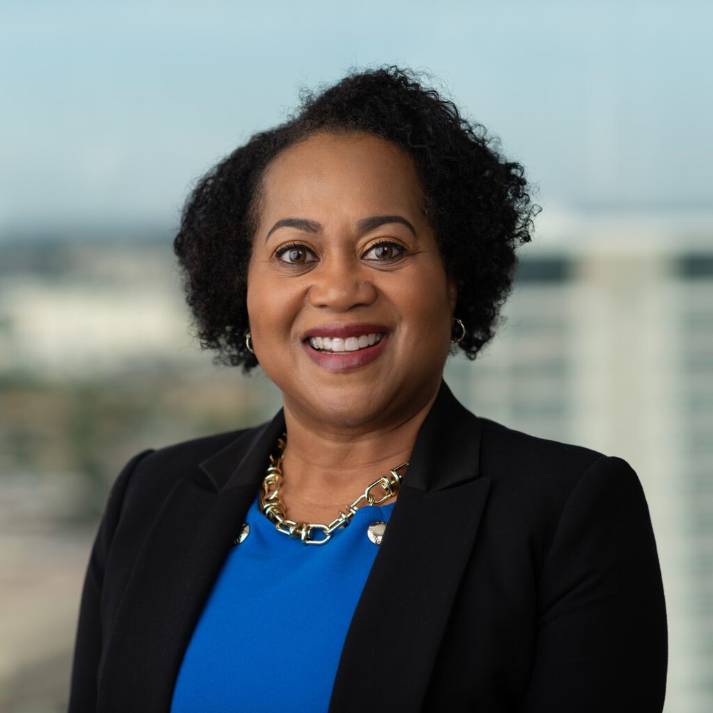 Smiling woman in blue and black outfit.