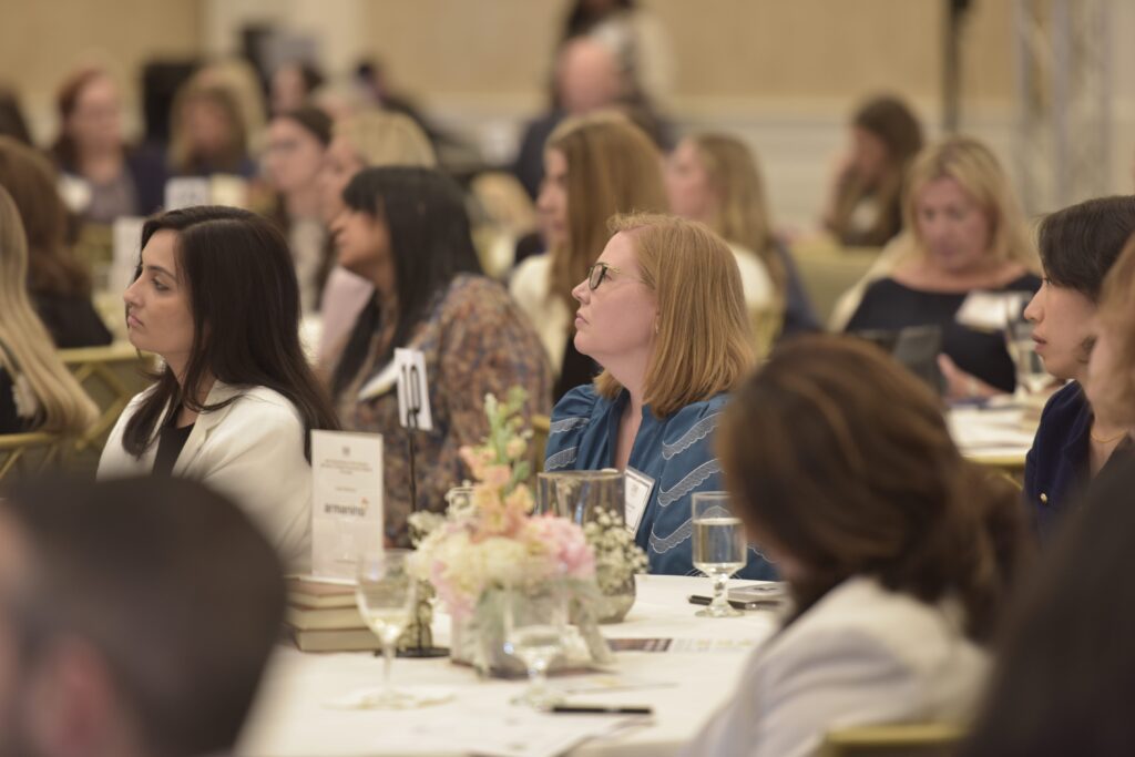 Audience members seated around floral centerpiece