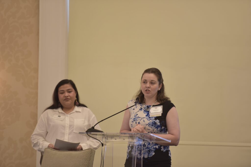 Two women speaking at a podium event.