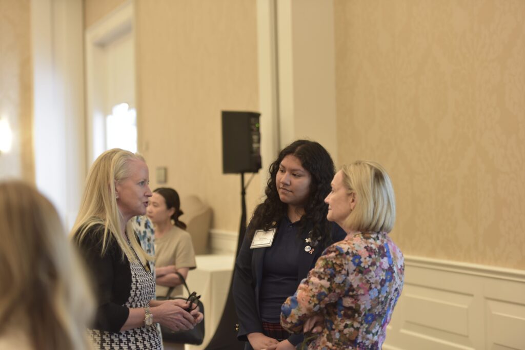 Three women engaged in conversation indoors.