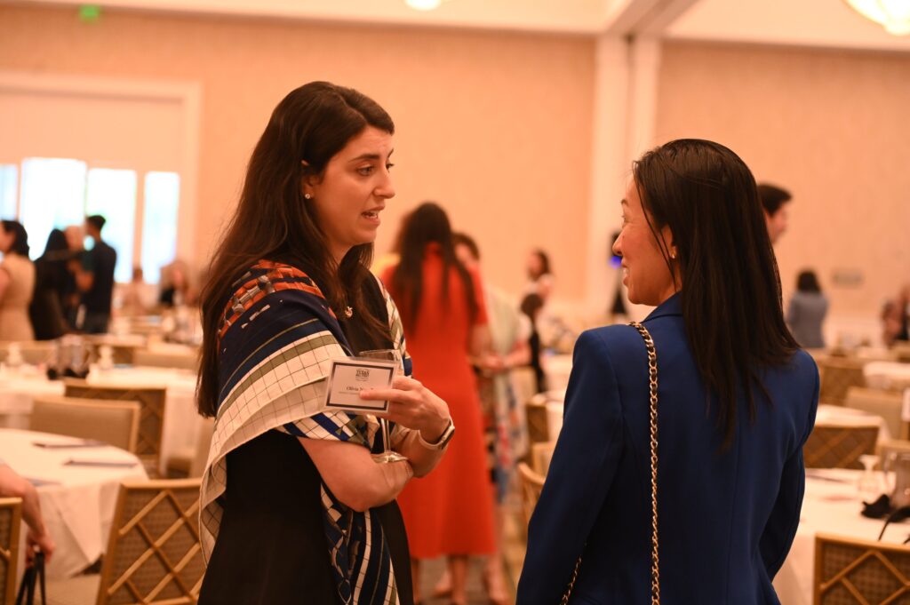 Woman with patterned scarf speaking to guest