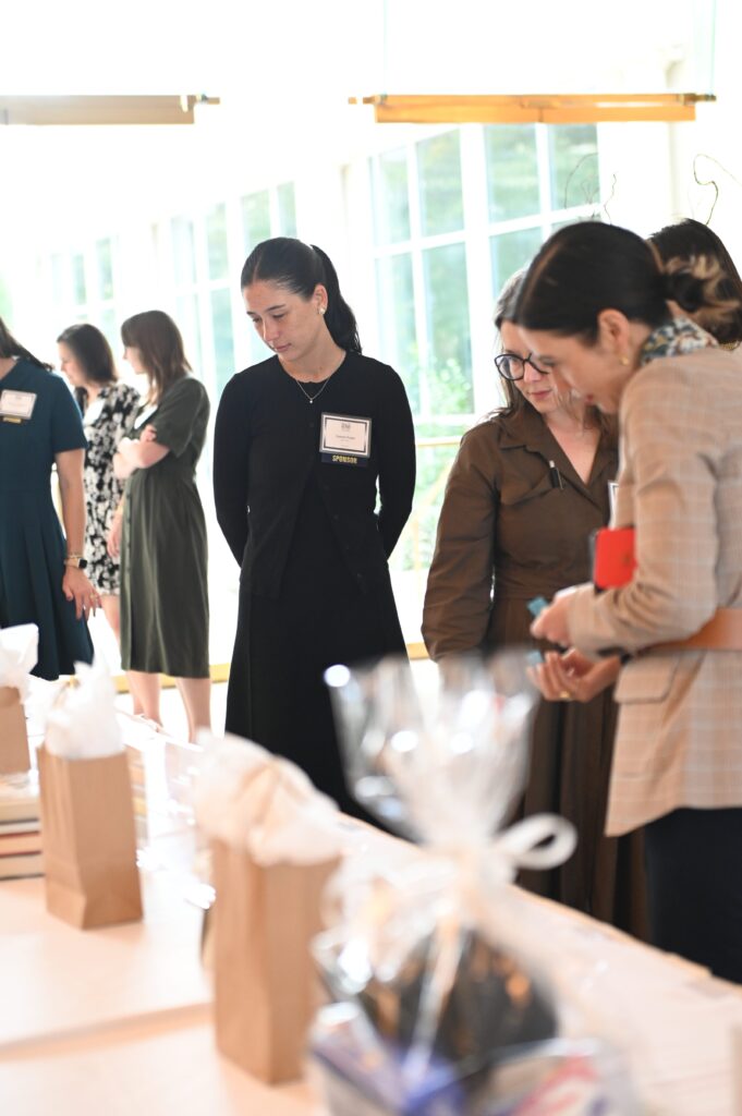 People observing table with gift bags.