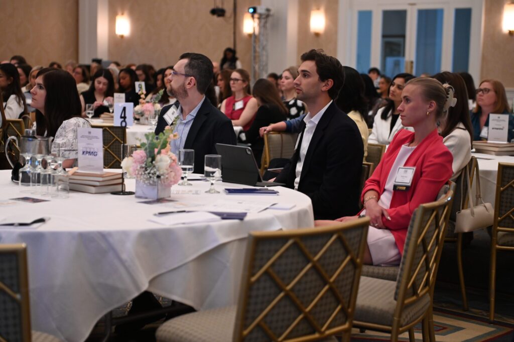 People attending a formal event, seated attentively.