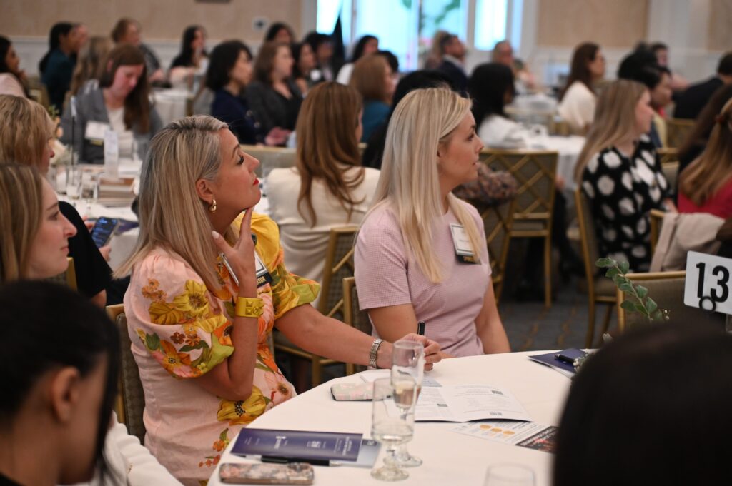 Two women at round table taking notes