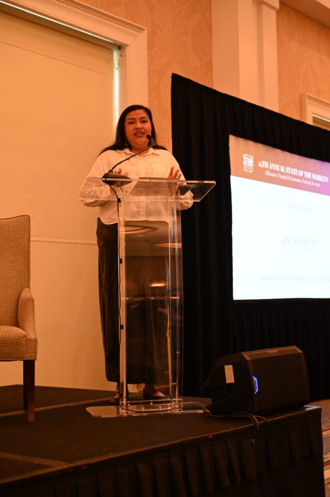 Speaker presenting at a conference podium.